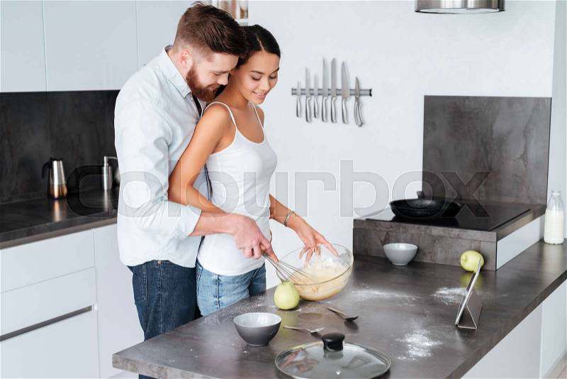 Young couple prepared cake. man costs from behind, stock photo