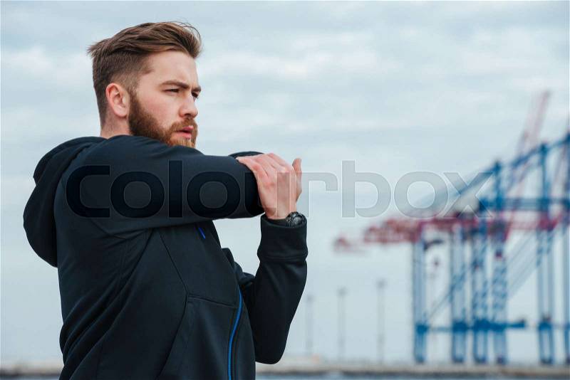 Warming up runner in profile. near the sea, stock photo