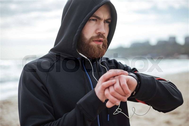 Runner on hood notes the time on beach, stock photo