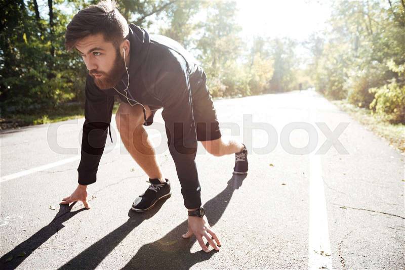 Man preparing to run in park. front view, stock photo