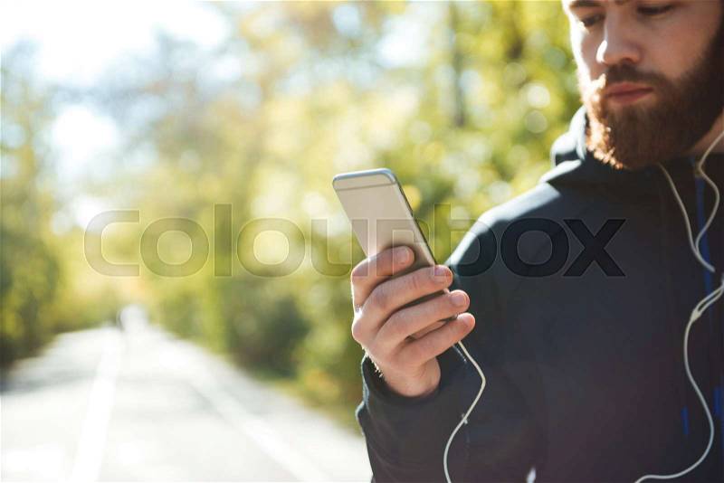 Athletic runner with phone in park. cropped image, stock photo