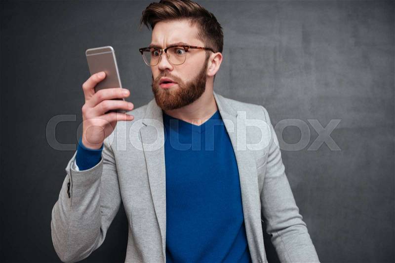 Hipster with phone. looking at phone. in studio. isolated black background, stock photo