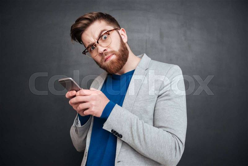 Funny hipster with phone. looking at camera. isolated black background, stock photo