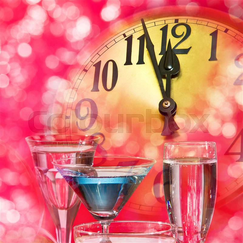 New year clock and wine glasses on the pink background, stock photo