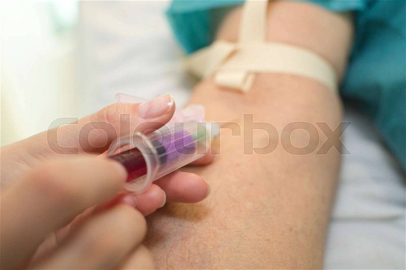 Nurse pricking needle syringe to collect blood, stock photo