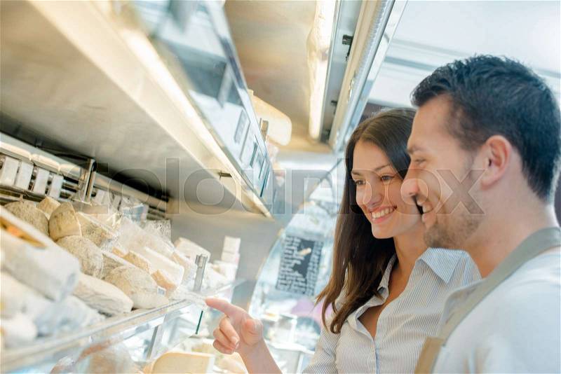 Couple browsing the cheese aisle, stock photo