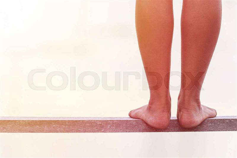 Bare feet standing on wooden bridge edge. Suicide concept, stock photo