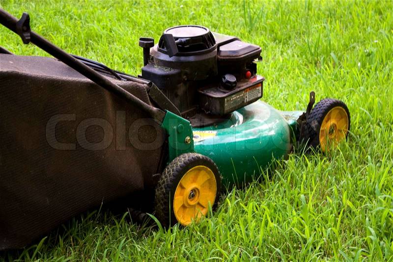 A modern lawn mower cutting through the grass, stock photo