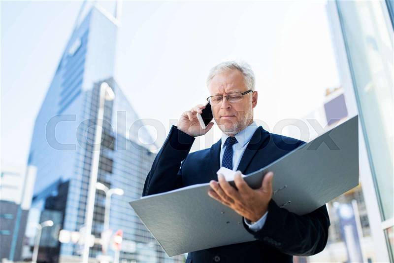 Business, technology, communication and people concept - senior businessman with document folder calling on smartphone in city, stock photo
