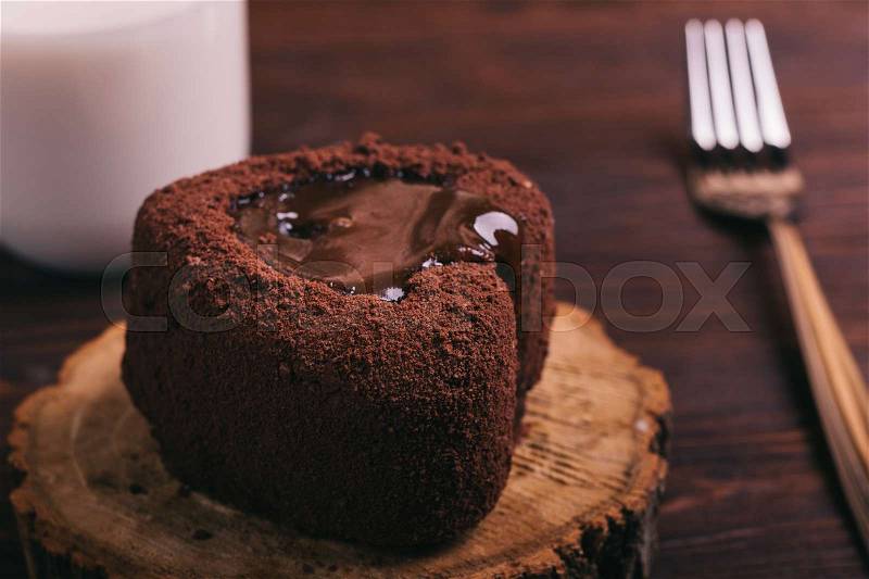 Chocolate cake, a glass of milk and a fork on a table cloth on the table brown, close-up, stock photo