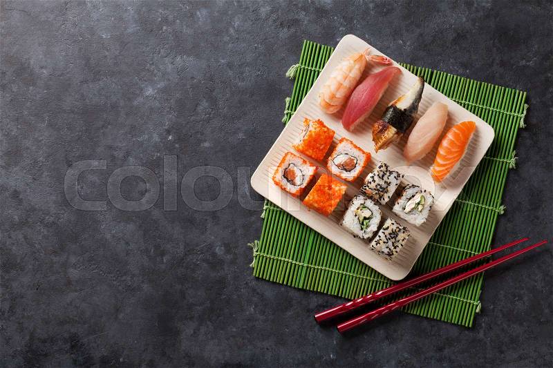 Set of sushi and maki roll on stone table. Top view with copy space, stock photo