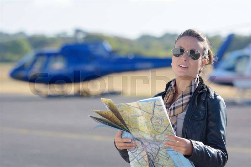 Pilot holding a map with the background planes, stock photo