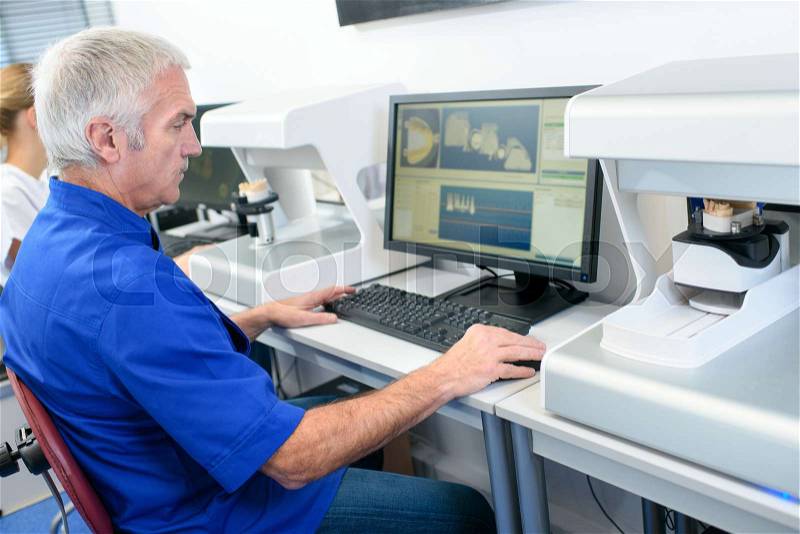 Serious researcher looking at computer screen in the laboratory, stock photo