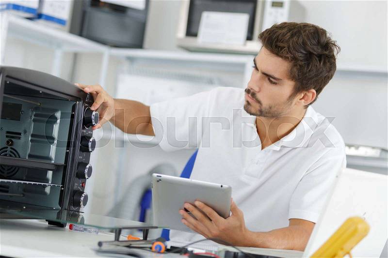 Attractive repairman concentrated at work, stock photo