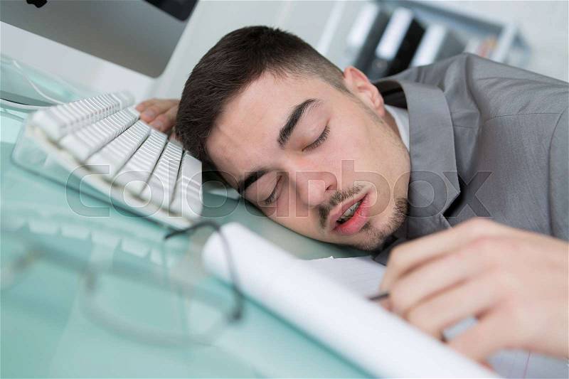 Man tried from working and sleeping on working desk, stock photo