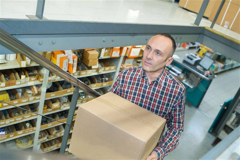 Man carring a carton box in a store, stock photo