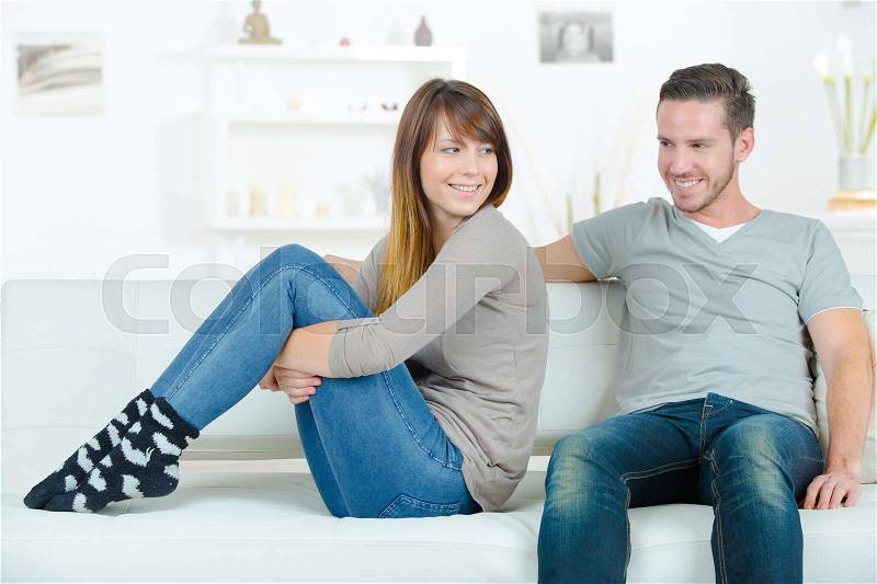 Young happy couple on sofa, stock photo