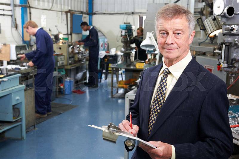 Owner Of Engineering Factory With Staff In Background, stock photo
