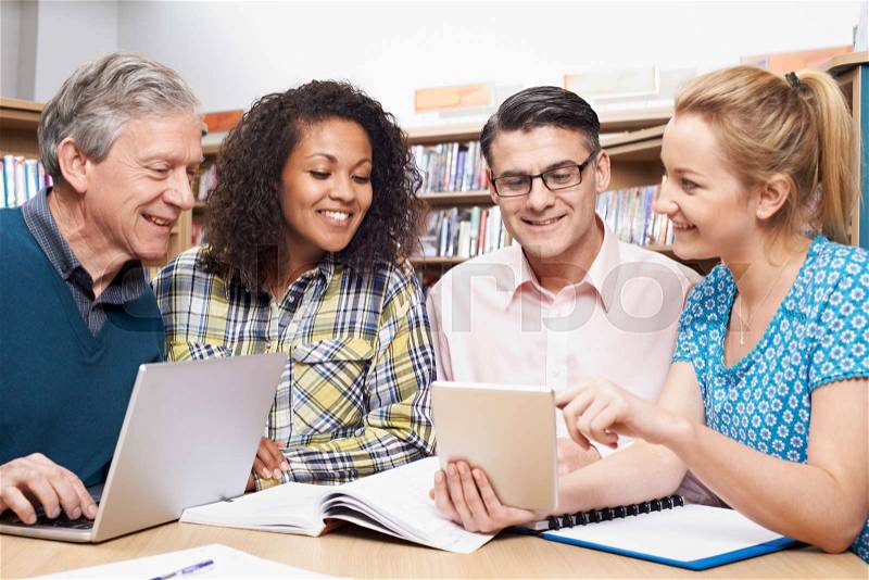 Group Of Mature Students Studying In Library, stock photo
