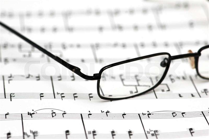 Black reading glasses over the music sheets, stock photo