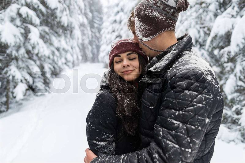 Young Romantic Couple In Snow Forest Outdoor Man And Woman Embrace Winter Pine Woods, stock photo