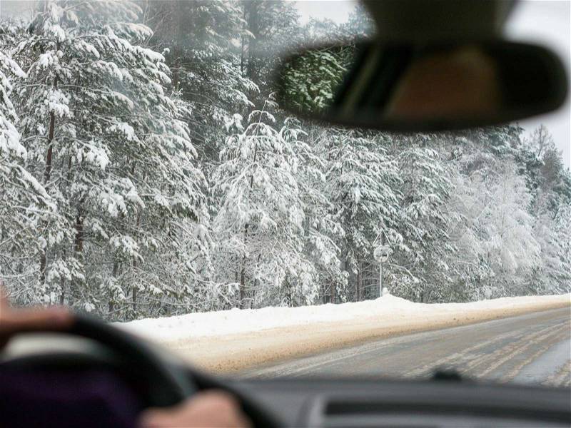 Winter driving. View from inside vehicle, unrecognizable driver, stock photo