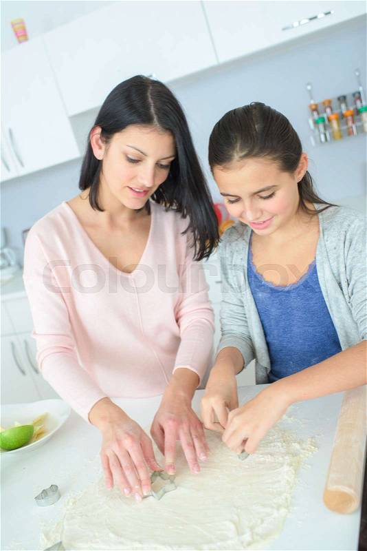 Mother and daughter preparing a cake, stock photo