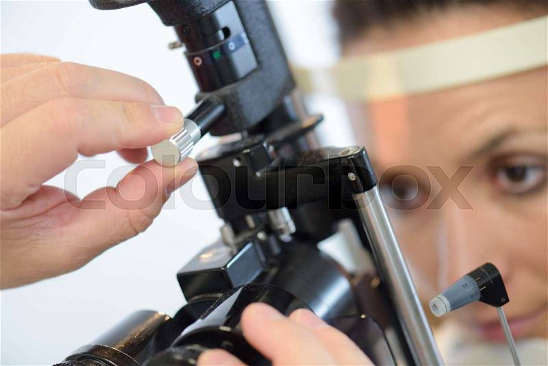 Woman having eye test at eye test machine, stock photo