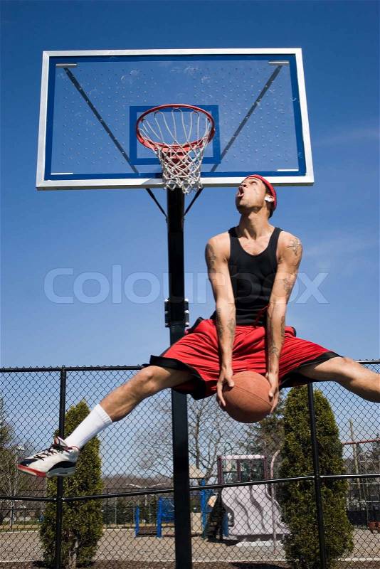 A young basketball player driving to the hoop, stock photo