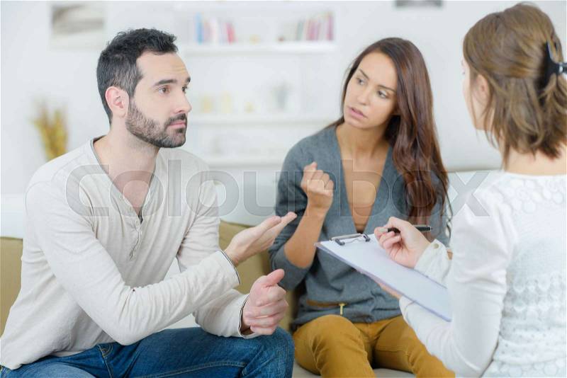 Stressed young couple quarrel at the psychologist, stock photo