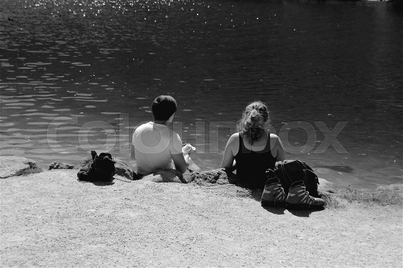 The couple, boy and girl have a break and have a beautiful view over the lake in the wonderful summer in black and white, stock photo