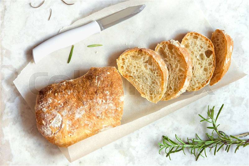 Italian bread Ciabatta and rosemary on white marble background - fresh homemade bread bakery, stock photo