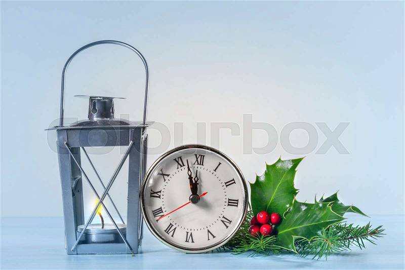 Christmas lantern with Holly leaves and berries and Christmas clock, stock photo