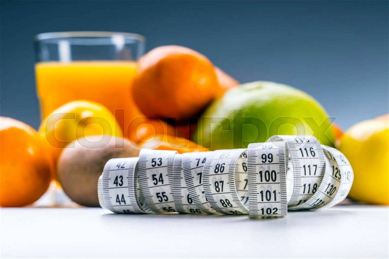 Measure tape and fresh fruit in the background. Healthy lifestyle diet with fresh tropical fruits, stock photo