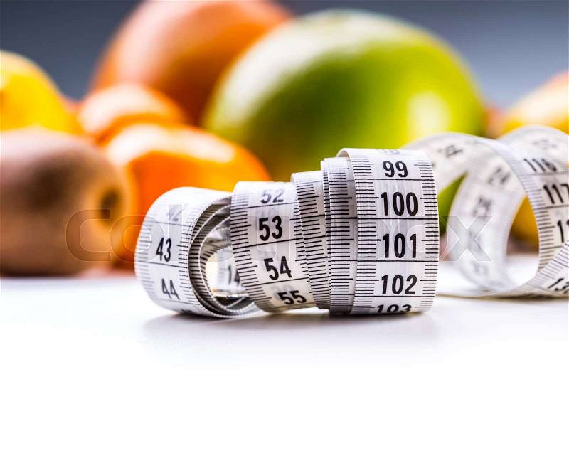 Measure tape and fresh fruit in the background. Healthy lifestyle diet with fresh tropical fruits, stock photo