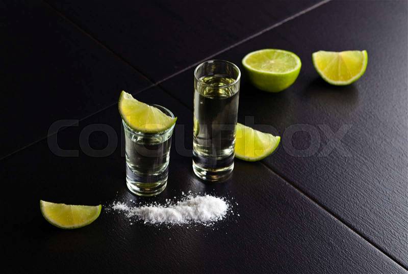 Tequila , lime and salt on black table, stock photo