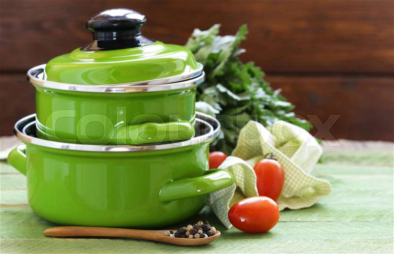 Green cooking pot and ingredients for soup or stew on rustic background, stock photo