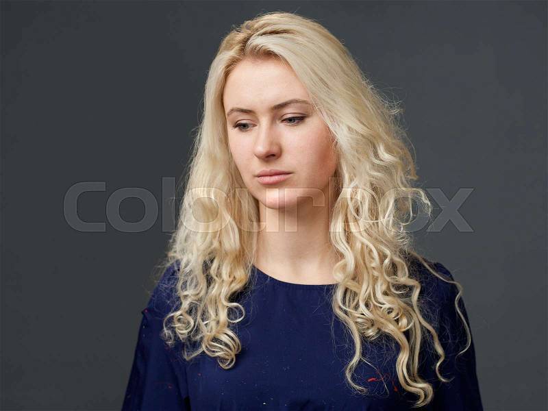Sad woman looked down, gray background, stock photo