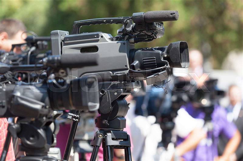 Press conference. Television camera in focus against blurred bac, stock photo