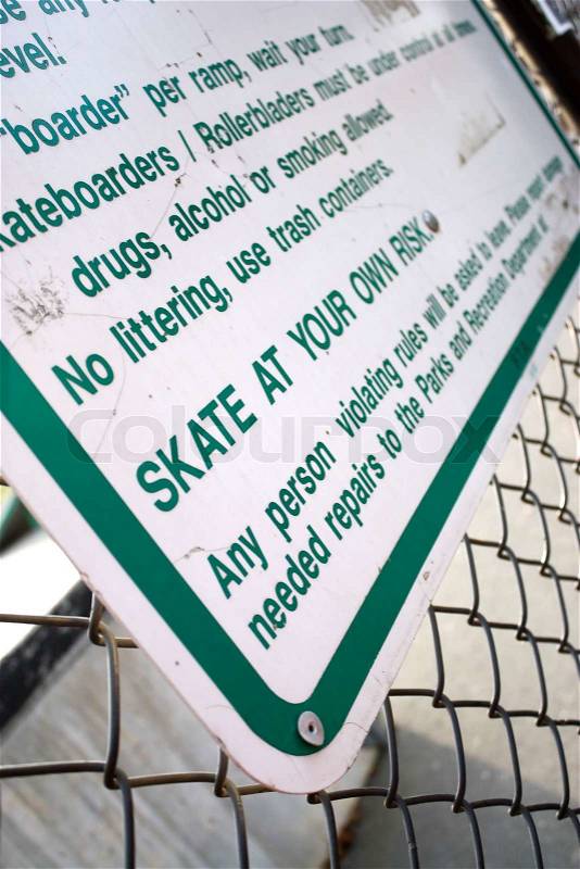 A sign at the skate park clearly states that you will skate at your own riskShallow depth of field, stock photo