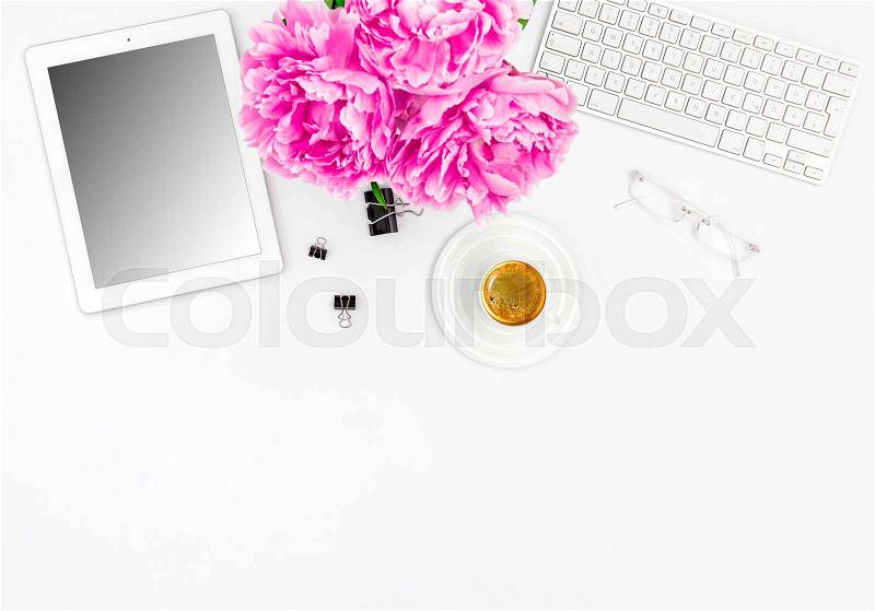 Feminine office workplace with coffee and flowers. Mockup with digital tablet screen, stock photo