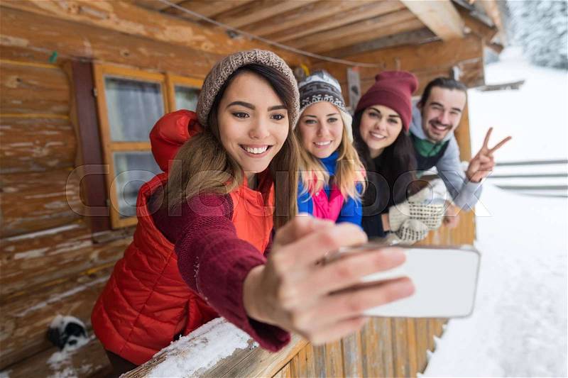 People Group Taking Selfie Photo Smart Phone Wooden Country House Terrace Winter Mountain Resort Friends On Vacation, stock photo