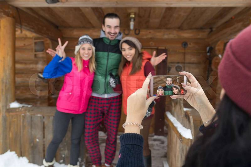 Girl Taking Photo On Smart Phone People Group Wooden Country Mountain House Winter Snow Resort Cottage Friends On Vacation, stock photo