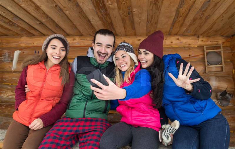 People Group Taking Selfie Photo Smart Phone Wooden Country House Terrace Winter Mountain Resort Friends On Vacation, stock photo