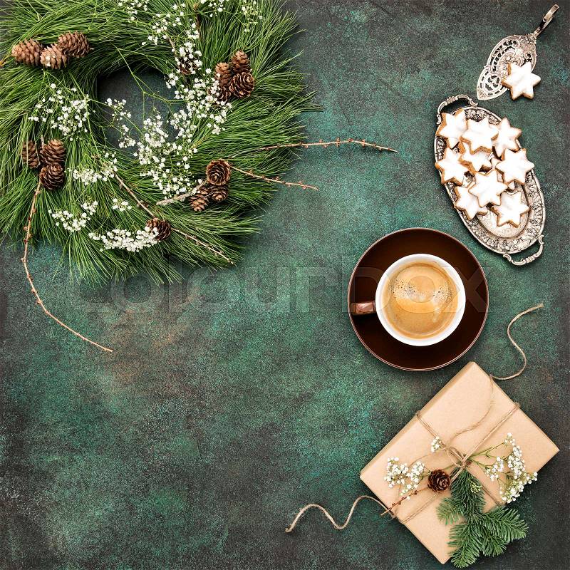 Christmas wreath, star cookies, coffee and wrapped gift. Vintage style toned picture, stock photo