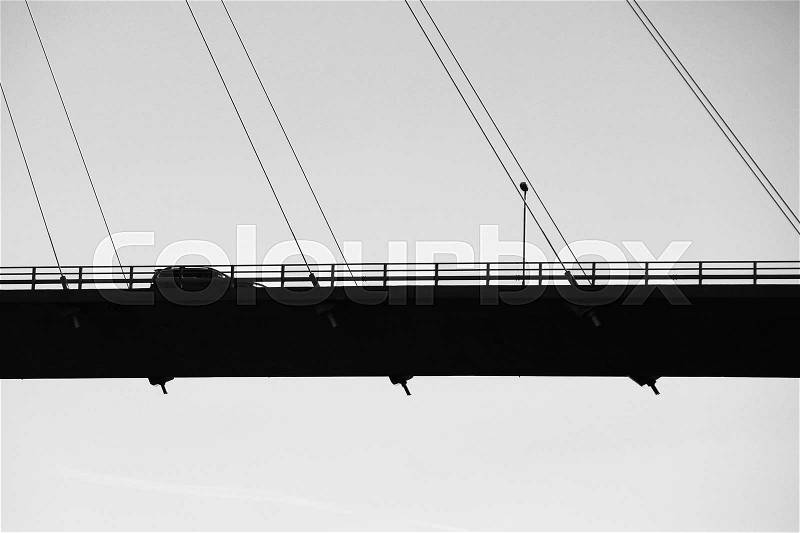 Car drives on modern automotive cable-stayed bridge in Norway, silhouette black and white photo, stock photo