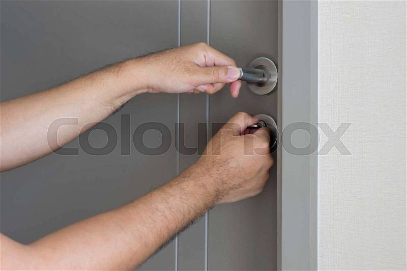 Locksmith will open the door with two hand and key - can use to display or montage on products, stock photo
