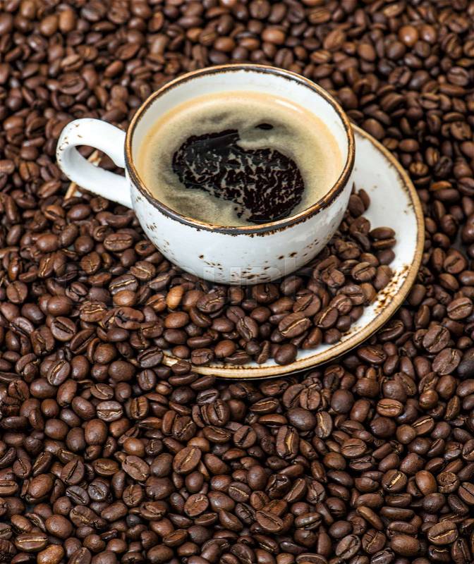 Food and drinks. Black coffee on coffee beans background, stock photo