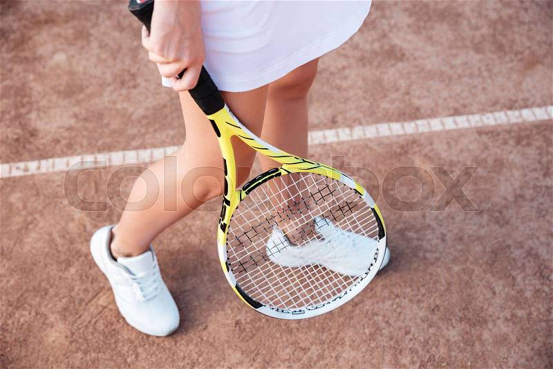 From above legs of tennis woman on court with racket, stock photo