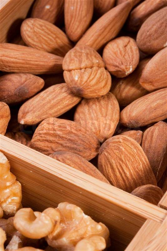 Nuts Almond in a wooden box together with nuts of other grades, stock photo